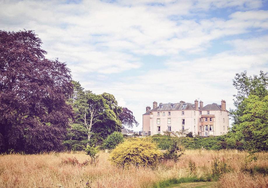 Colstoun House surrounded by grass and trees